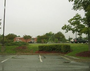 Photo of grass and parking lot on a rainy day.
