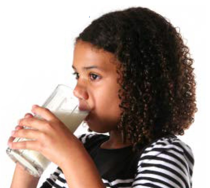 A girl drinks glass of milk.