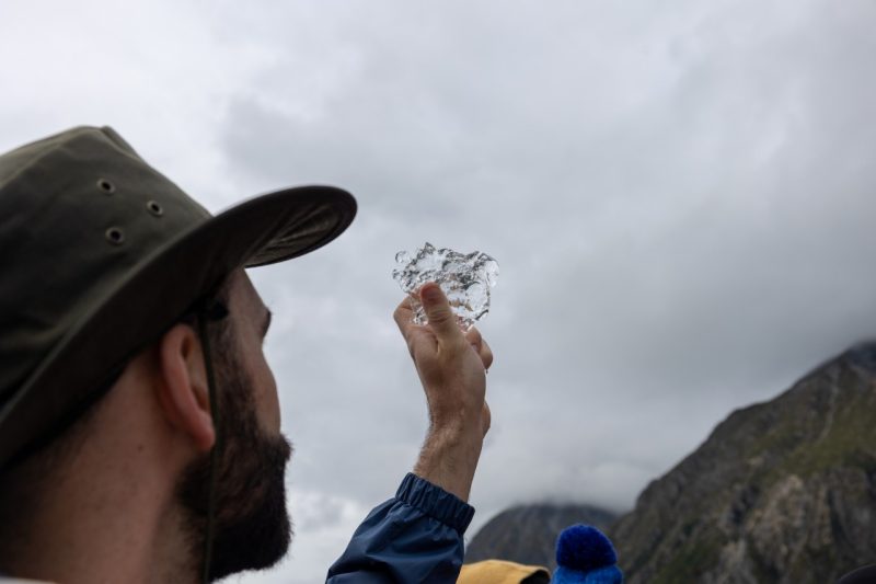 man holds a piece of an iceberg