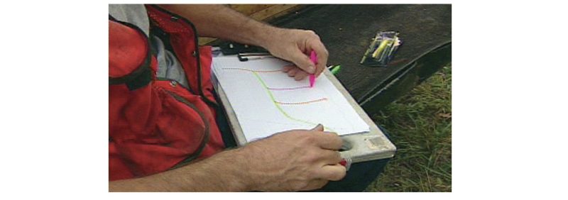 a photo of a person drawing on a notebook outdoors.