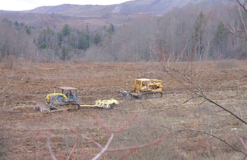 Figure 9. Preparing an area for reforestation research at Powell River Project Research and Education Center. The large disk (left) is used first to break up the sod, then an advanced deep-tillage device (right), was used to prepare the land for planting.