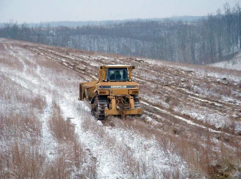 Figure 5. A standard single-shank ripper preparing a mine site for reforestation. The soil-ripping “tooth” being pulled by the dozer is intended to loosen soil material to a depth of 3 feet or more. The best results are achieved if this operation is performed in late summer and fall when the soil is dry.