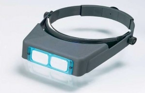 A pair of optical headband magnifiers with two magnifying lenses at the front.