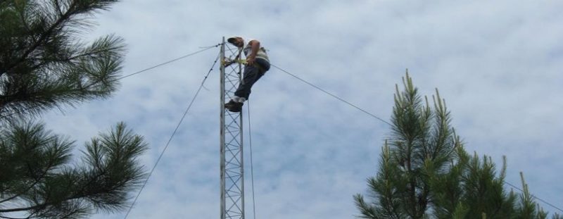A man standing on a tall metal tower.