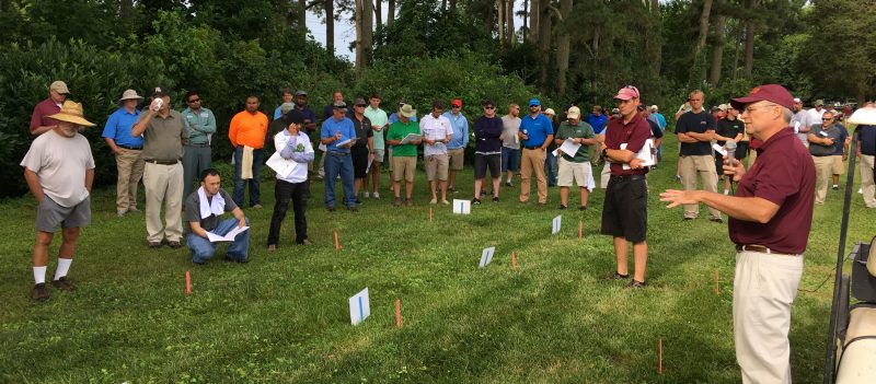 Photo of people explaining and listening on the field