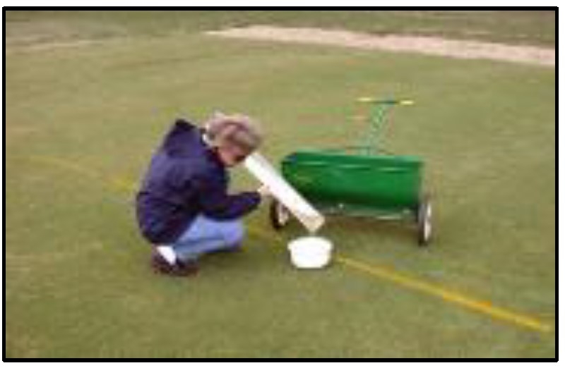 Photo of women attaching a calibration pan to a spreader