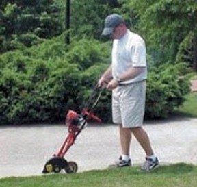 An image of someone demonstrating proper use of a lawn edger.