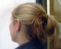 The back of a person's head depicting long hair tied up and off the shoulders.