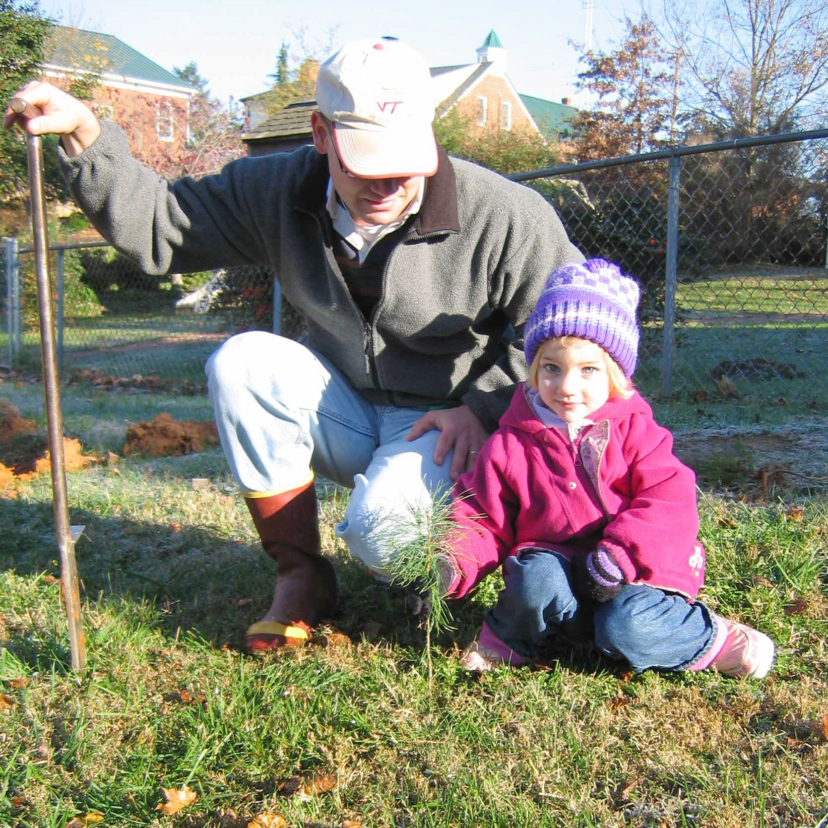 photo of a man and child with a seedling