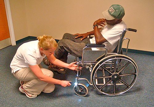 picture of a person inspecting a wheelchair