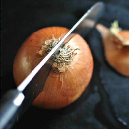 Photo of slicing a whole onion with a knife