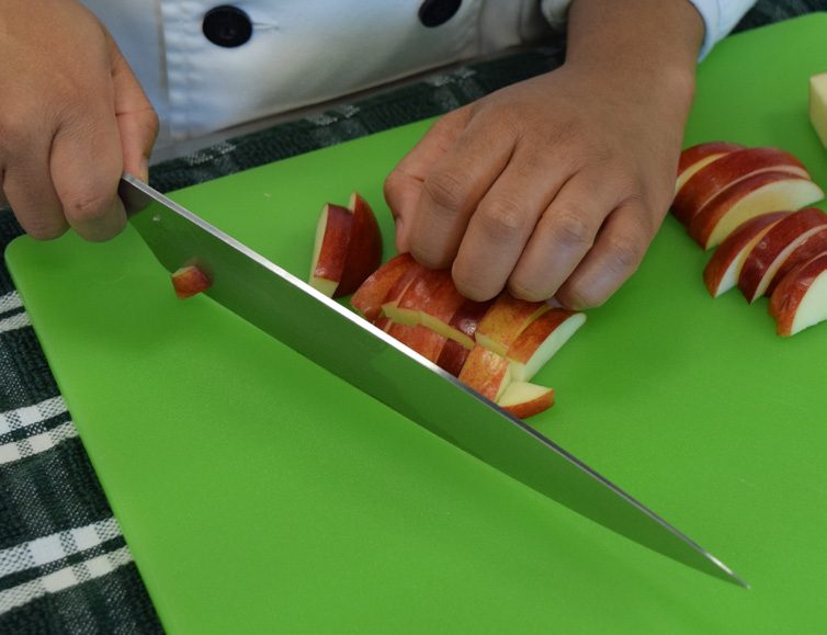 Photo of a person cutting an apple