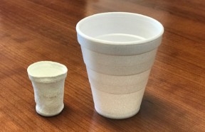 Two white Styrofoam foam cups side by side sitting on a brown surface. The Styrofoam cup on the left is shrunken and misshapen after being exposed to HPP due to the product’s high volume of air. A standard Styrofoam cup sits to the right for comparison.