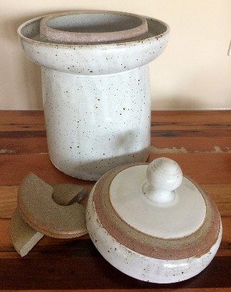 A ceramic crock and weights used for fermentation.