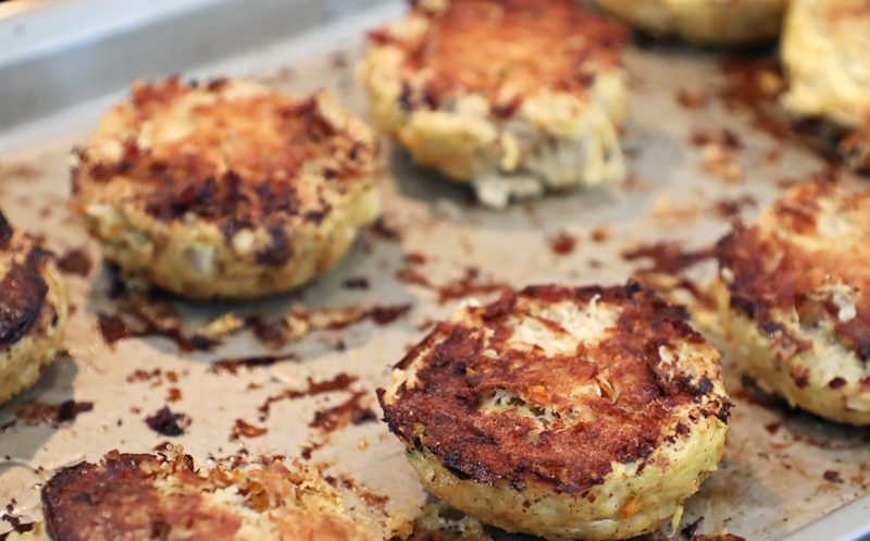 Cooked crab cakes on a baking sheet.