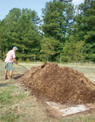 a photo of a person working on the compost pile