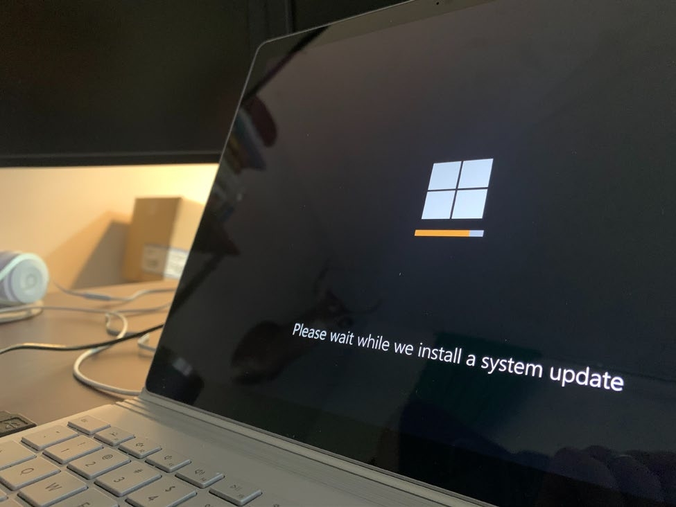 A picture containing a laptop with a screen showing an update is being installed. 