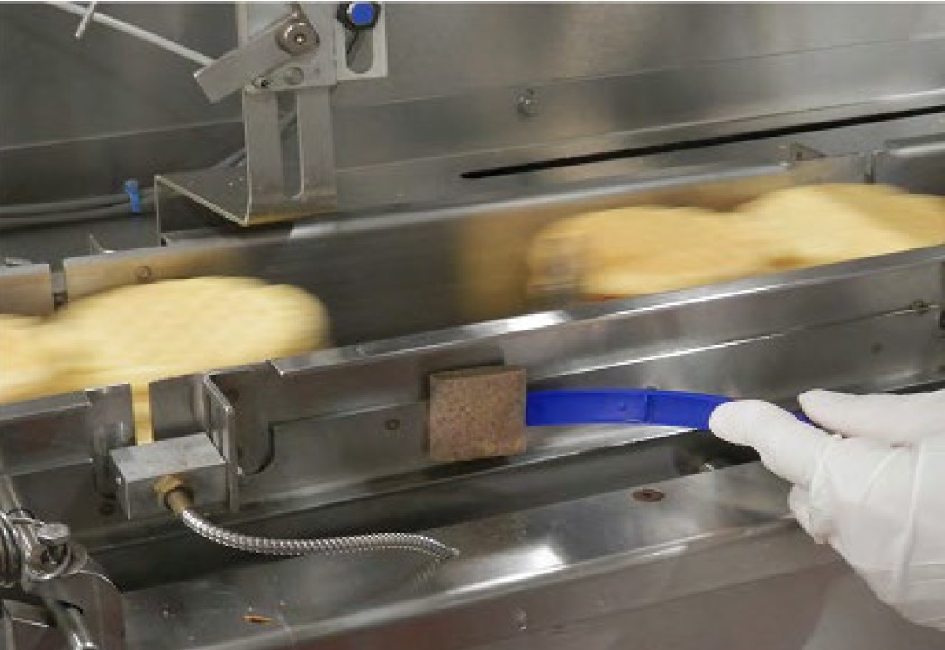 Environmental Sampling by FDA with sponge swab stick, swabbing surface of piece of equipment. 
