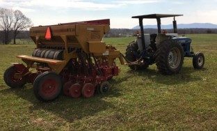 A Haybuster 107 C no-till drill hithed to a tractor.