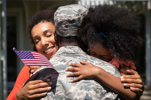 solider hugging family